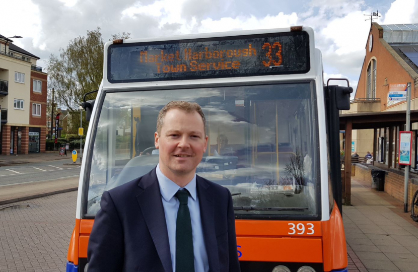 Neil O'Brien MP next to a local bus