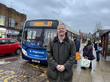 Neil O'Brien MP next to a local bus